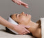 Person receiving a facial massage with a neutral background